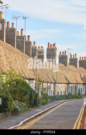 Eine Reihe von terrassenförmig angelegten Cottages mit steilen Dächern und hohen Schornsteinen auf der Orchard Street, in der Nähe der Innenstadt von Cambridge, England. Stockfoto