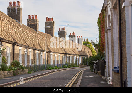 Eine Reihe von terrassenförmig angelegten Cottages mit steilen Dächern und hohen Schornsteinen auf der Orchard Street, in der Nähe der Innenstadt von Cambridge, England. Stockfoto