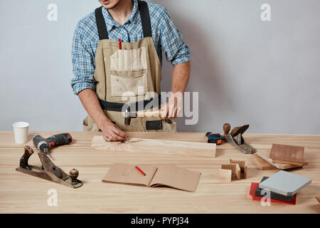 Die Tischler, Hämmern ein Nagel auf Holzbrett, Möbel. Stockfoto