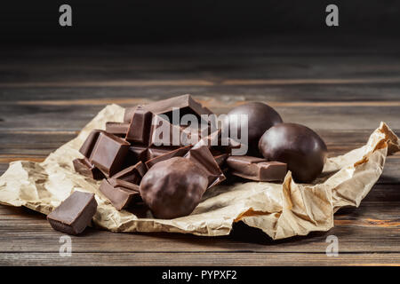 Scheiben von Schokolade, auf Backpapier auf einem Holztisch. Dunklen rustikalen Stil backen Konzept mit Kopie Raum Stockfoto