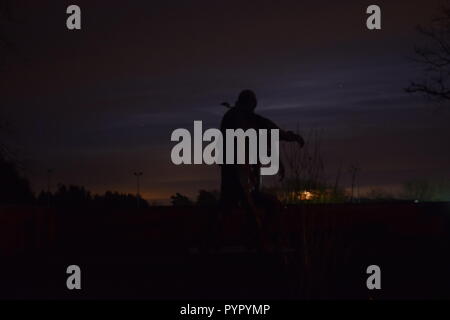 Timeline der aufgehenden Mond in der Nacht Dämmerung Himmel von einer Bronzeskulptur Silhouette in der soldatenfriedhof Reimsbach an der Saar Deutschland gesehen Stockfoto