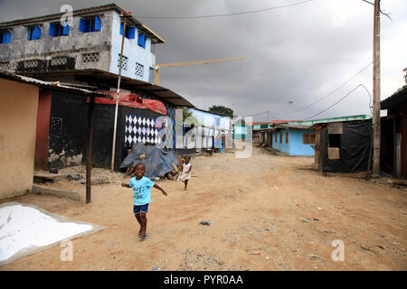 Junge und Mädchen laufen nach unten eine unbefestigte Straße vor einem regen Sturm in Blockhauss, Abidjan, Cote d'Ivoire Stockfoto