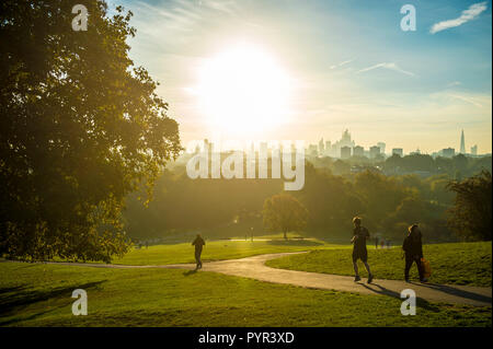 LONDON - ca. Oktober 2018: Jogger vor einem Sonnenaufgang Blick auf die Skyline der Stadt. Stockfoto