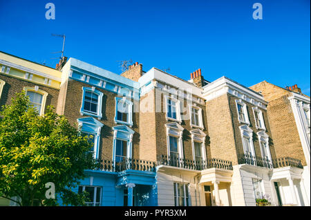 Classic Reihe von terrassenhäusern von traditionellen Gelb London Stock Backstein hell durch helle Sommer Sonne unter strahlend blauem Himmel Stockfoto