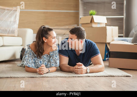 Mann und Frau auf dem Boden liegen nach dem Entpacken in ihrer neuen Heimat Stockfoto