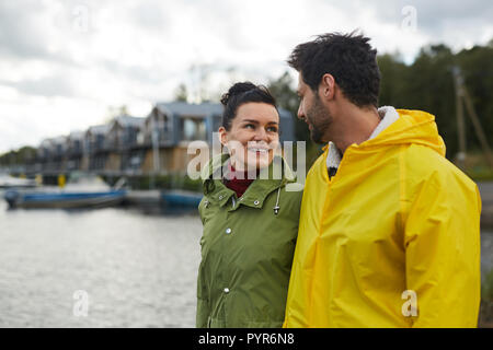 Paare, die in Liebe zu Fuß über Seehafen Stockfoto