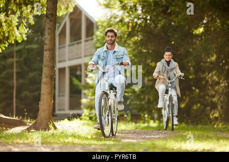 Aufgeregt Paar beim Fahrrad fahren im Wald Stockfoto