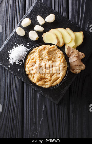 Frischer Ingwer und Knoblauch Paste oder Adrak Lahsun Püree in eine keramische Schüssel. Selektive konzentrieren. Vertikal oben Ansicht von oben Stockfoto