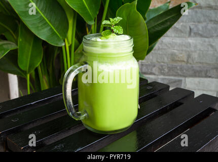 Grüner Tee Smoothies im Glas auf schwarzen Holztisch. Stockfoto