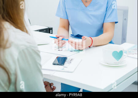In der Nähe der weiblichen Arzt und Patient an der Rezeption in der modernen Klinik sitzen Stockfoto