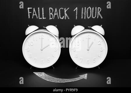 Zurück Konzept Herbst Zeit ändern. Zwei Vintage Uhren mit kalkhaltigem Text auf der Tafel Stockfoto