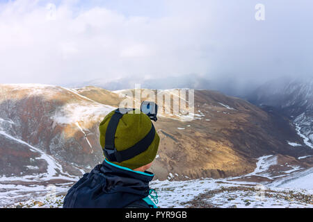 Portrait männlichen Bergsteiger in Snowy Mountains, mit einem Rucksack Stockfoto