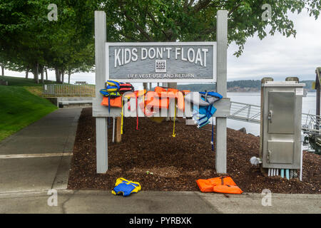 Schwimmweste und Return self service in Sequim Marina mit der Schlagzeile Kinder nicht schwimmen, Washington State, USA. Stockfoto