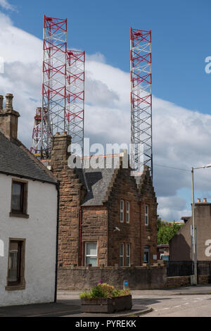 Bohranlage überragt Gebäude in der High Street Invergordon, Highland, Schottland, UK. Stockfoto