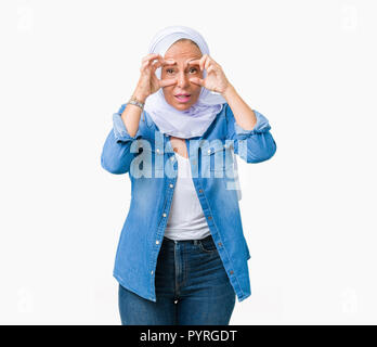 Mittleres Alter östlichen arabischen Frau mit arabischen Hijab über isolierte Hintergrund versuchen, Augen mit den Fingern, schläfrig und müde für morgendliche Müdigkeit zu öffnen. Stockfoto