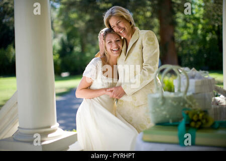 Junge Erwachsene Braut ihren reifen Mutter umarmt, während außerhalb. Stockfoto