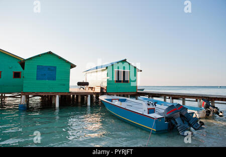Angelegte Boote Neben boatsheds auf einem Steg in der Sonne. Stockfoto