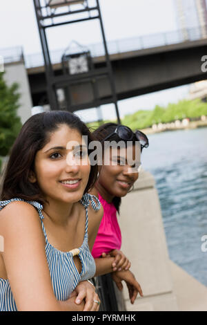 Zwei junge Frau lehnte sich auf das Geländer einer Brücke in der Nähe einer innerstädtischen River. Stockfoto