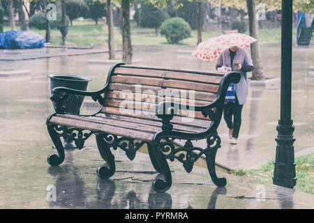 Nasse Bank unter dem Regen im City Park Stockfoto