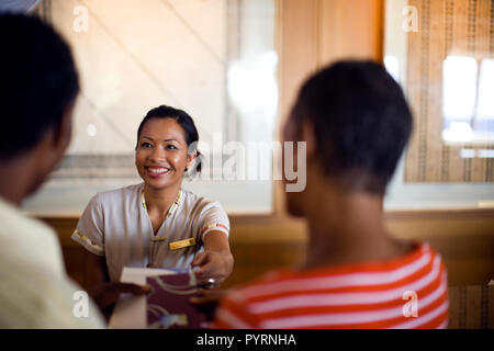Rezeptionist Kontrolle ein Paar in ihre Hotelzimmer. Stockfoto