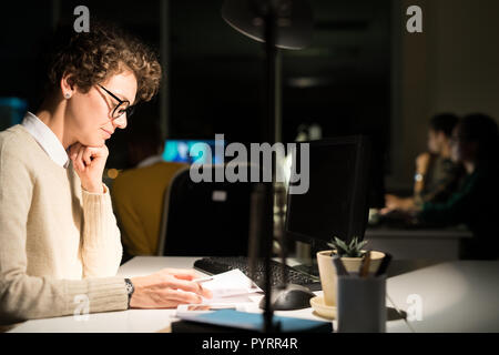 Frau Arbeiten in dunklen Büro Stockfoto