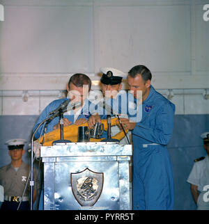 (18 Dezember 1965) - - - Astronauten Frank Borman (links), Gemini-7 Befehl Pilot, und James A. Lovell jr., Pilot, Zeit nehmen während ihrer Begruessung an Bord der Flugzeugträger USS Wasp eine Schwimmweste zu Autogramm. Stockfoto