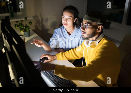 Kollegen schlichten Projekt bei Nacht Stockfoto