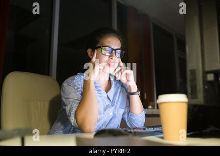Betonte Frau Arbeiten bei Nacht Stockfoto