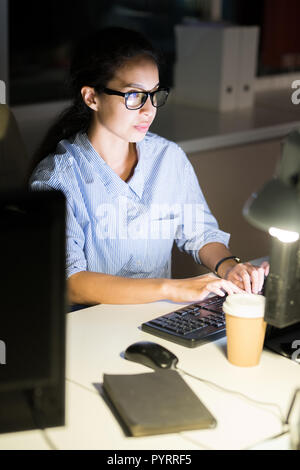 Junge Frau Arbeiten bei Nacht Stockfoto
