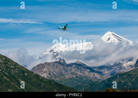 Schwimmer Wasserflugzeug und Mount Redoubt, Lake Clark National Park, Alaska, USA. Stockfoto