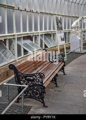 Eine Bank und eine Skulptur in Marmor im Arboretum in den Botanischen Garten in Glasgow, Schottland, UK, auf einem Juli Sommer am Nachmittag. Stockfoto