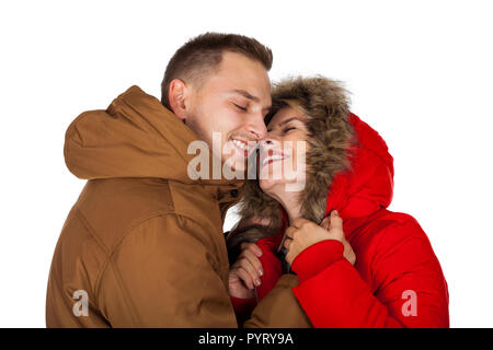 Junges Paar das Tragen der roten und braunen Winter parka Jacke posiert auf isolierten Hintergrund - Saisonale mode bekleidung
