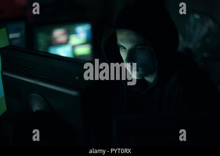 Junge professionelle Hacker in einem dunklen Büro mit Computer, Cyber Security und Hacking Konzept Stockfoto