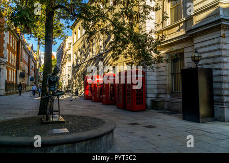 5 rote Telefonzellen und Skulptur in Covent Garden, London England United Kingdom Stockfoto