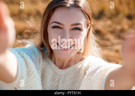 Glücklich lächelnde junge Frau macht selfie und Genießen der Natur im Herbst. Stockfoto