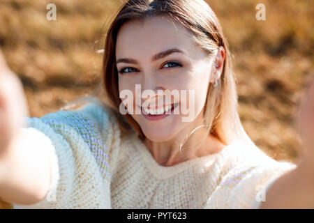 Glücklich lächelnde junge Frau macht selfie und Genießen der Natur im Herbst. Stockfoto