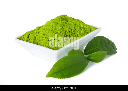 Green Matcha Tee Pulver in weiße Schüssel mit grünen Teeblätter auf weißem Hintergrund Stockfoto