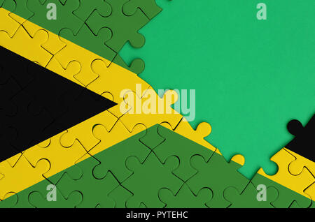 Jamaika Flagge ist auf einer abgeschlossenen Puzzle mit Freie grüne Kopie Raum auf der rechten Seite dargestellt. Stockfoto