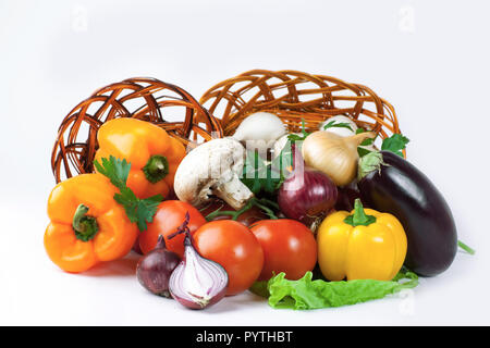 Pilze und eine Vielzahl von frischem Gemüse in einem Weidenkorb. Stockfoto