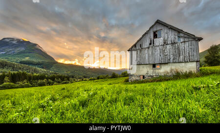 Sunset over mountains and Old barn in Norwegian countryside near Stranda in More og Romsdal province Norway Stockfoto