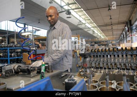Tuareg einwandernde Gemeinschaft in Pordenone, Italien; Mohamed Abety an seinem Arbeitsplatz in einer Fabrik Textilmaschinen Stockfoto