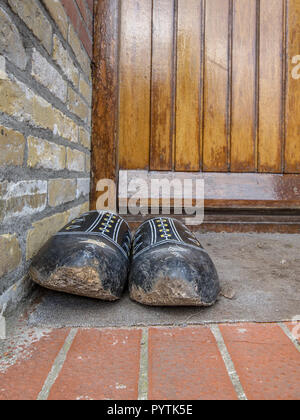 Holzschuhe vor einem braunen farm Tür Stockfoto