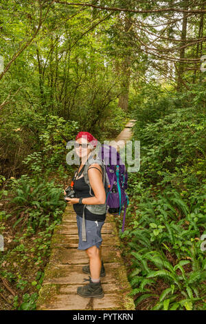 Mittleres Alter Frau wandern, Cape Alava Trail, gemäßigten Regenwald, in der Nähe von Cape Alava, Pazifikküste, Olympic National Park, Washington State, USA