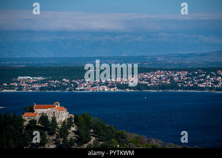 Kirche und Kloster der Heiligen Cosmas und Damian auf der Insel Pasman mit Sveti Filip i Jakov und Biograd na Moru im Hintergrund. Stockfoto