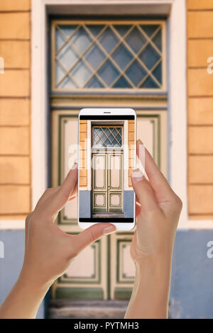 Ein Tourist ist ein Foto der alten schönen Tür in der Altstadt von Tallinn, Estland auf einem Mobiltelefon Stockfoto