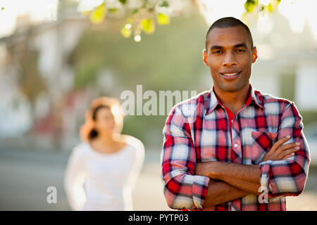 Portrait von lächelnden Mitte erwachsenen Mann mit seiner Freundin im Hintergrund. Stockfoto