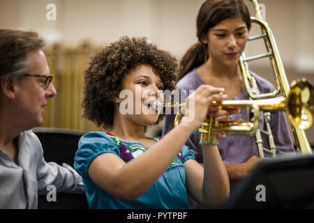Junges Mädchen lernen, Trompete zu spielen. Stockfoto