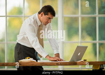 Mitte der erwachsenen Geschäftsmanns, der auf einem Laptop. Stockfoto