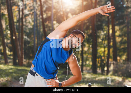 Junge athletische multikulturellen bärtigen Mann mit Brille sportish seine Lieblingsmusik hören, während seine morgen Übung, gesunden Lebensstil und Menschen Konzept Stockfoto