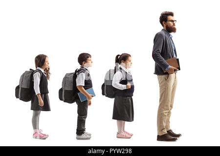 Volle Länge Profil Aufnahme von Schulkindern in Zeile hinter männlichen Lehrer auf weißem Hintergrund warten Stockfoto